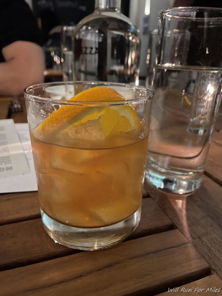 a glass of liquid with a slice of orange on top of it