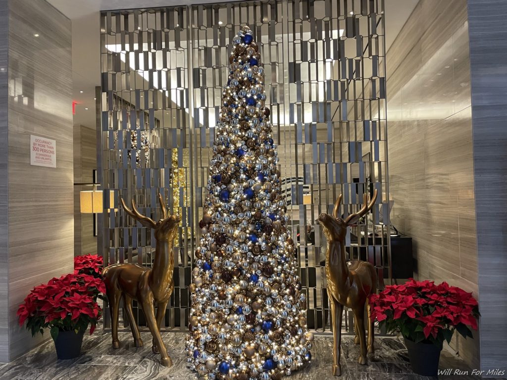 a christmas tree with ornaments and reindeer statues