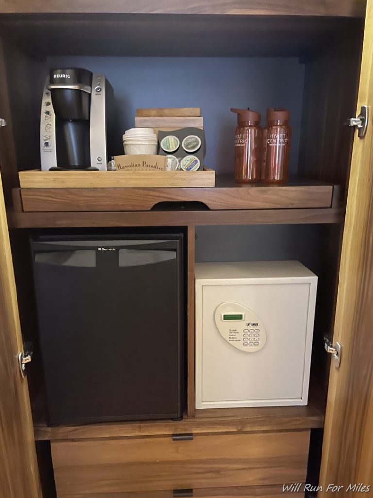 a small refrigerator and coffee maker on a shelf