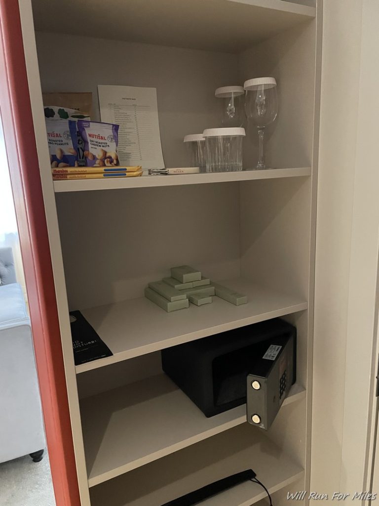 a shelf with a safe and glasses on it