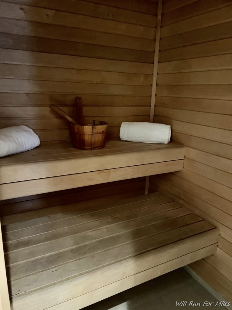 a wooden sauna with a bucket and towels