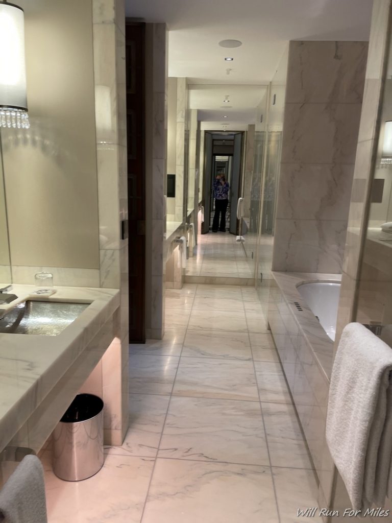 a bathroom with marble tile flooring and a sink and mirror