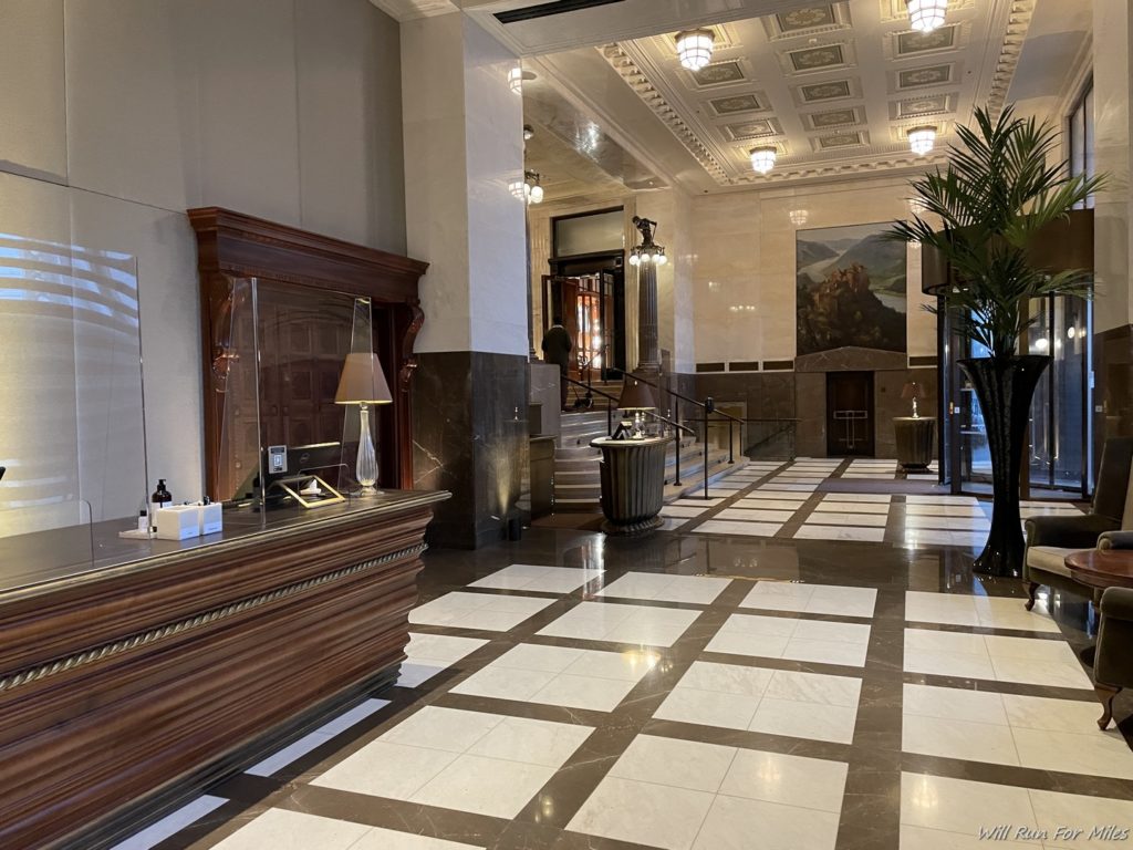 a lobby with a marble floor and a large mirror