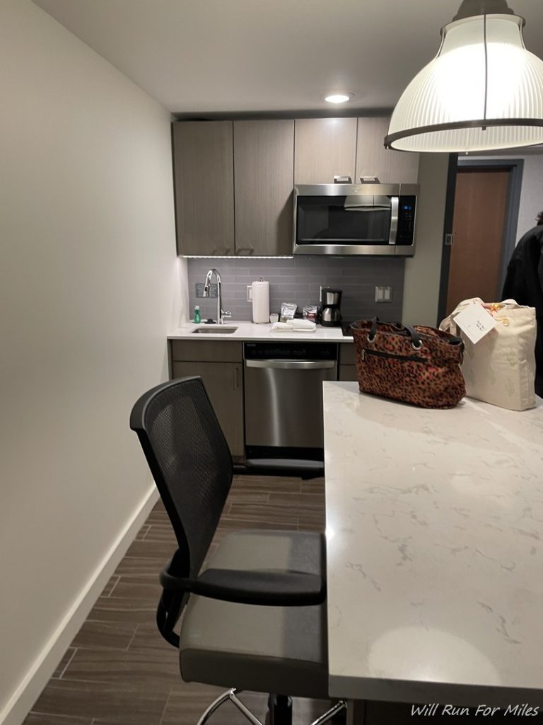 a kitchen with a chair and a bag
