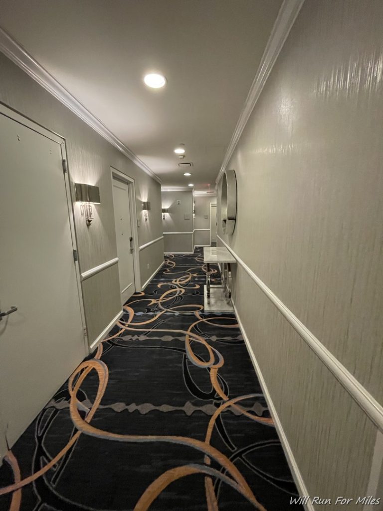 a hallway with a carpeted floor and doors