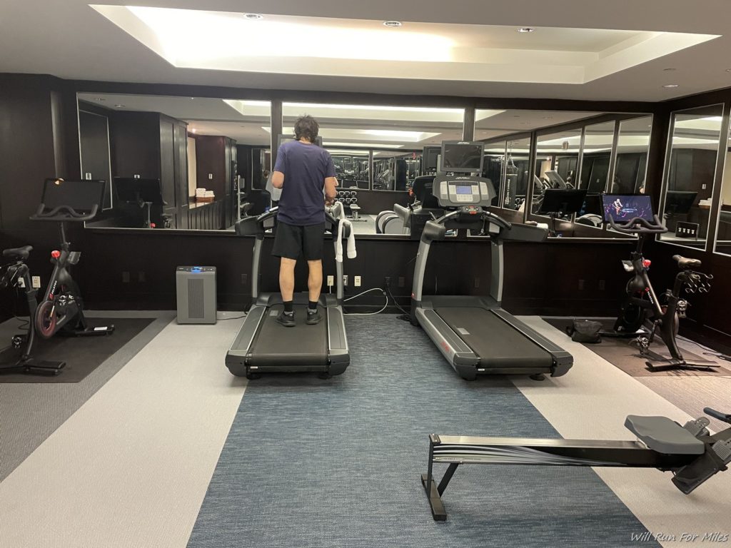a man standing on treadmills in a gym