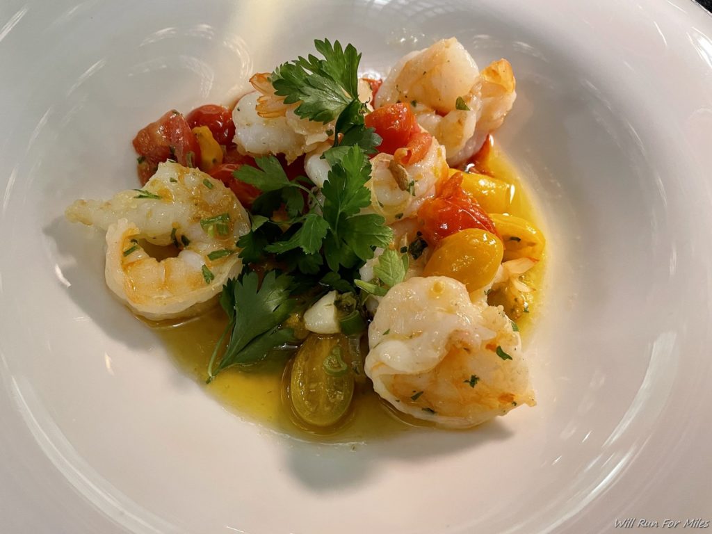 a plate of food with shrimp and tomatoes