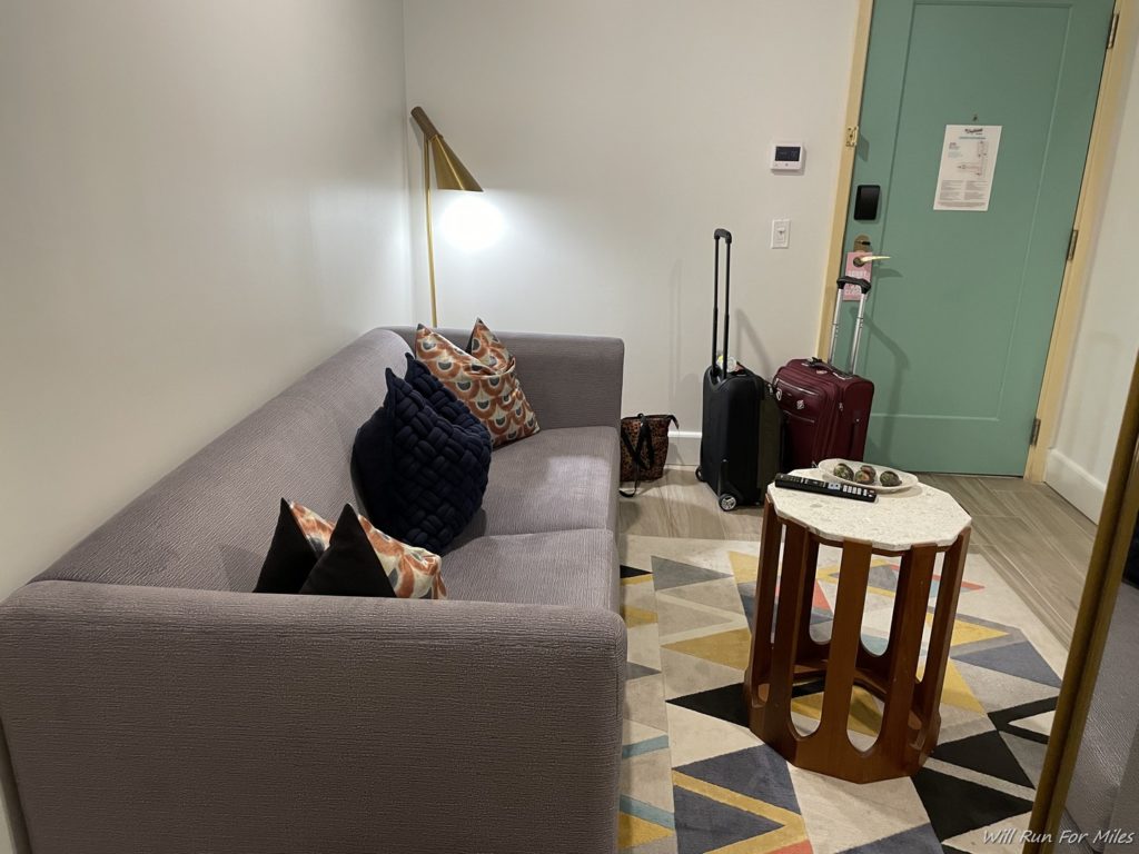 a couch with pillows and a table with luggage