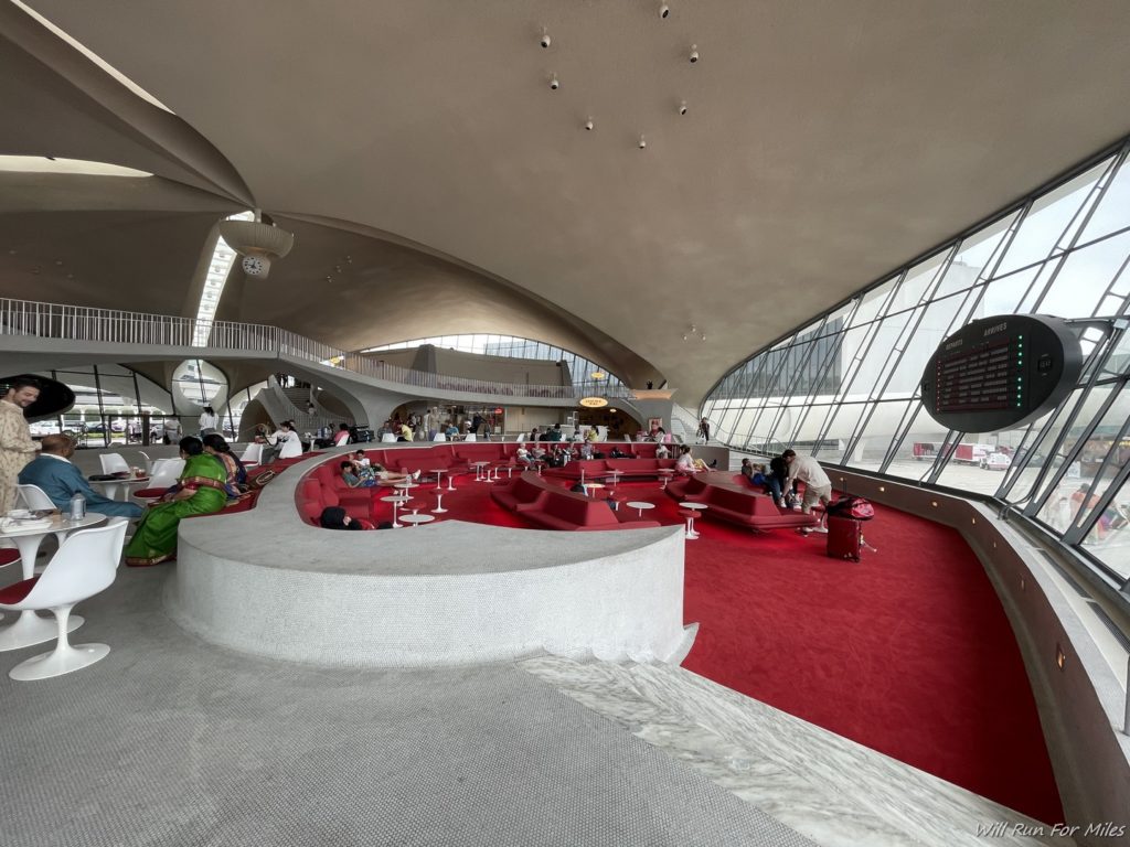 a large circular area with red carpet and people sitting on it