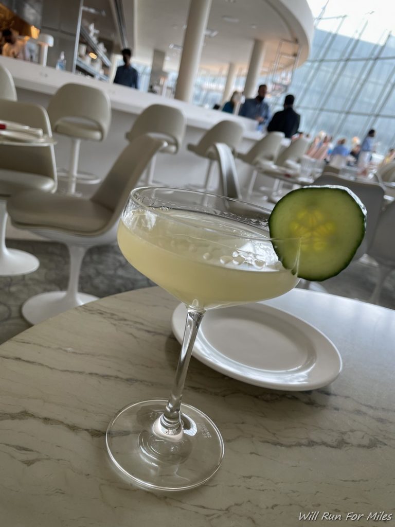 a glass with a cucumber slice on top of it