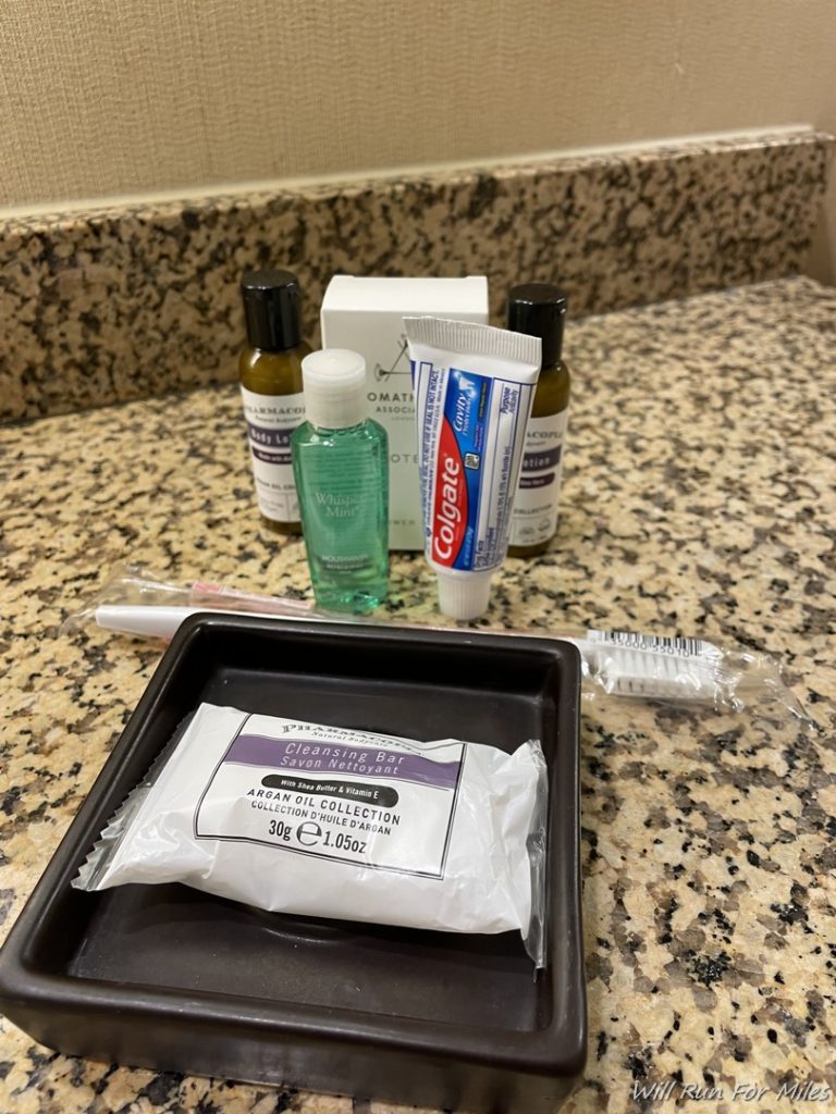 a small plastic tray with a white packet on it next to a group of toothbrushes and toothpaste