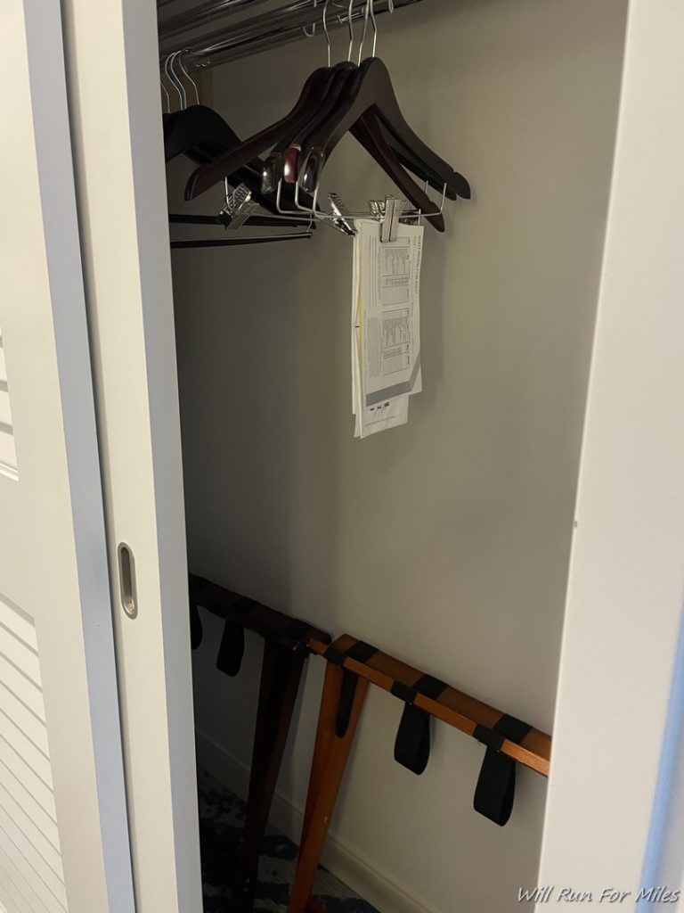 a closet with clothes on a swinger