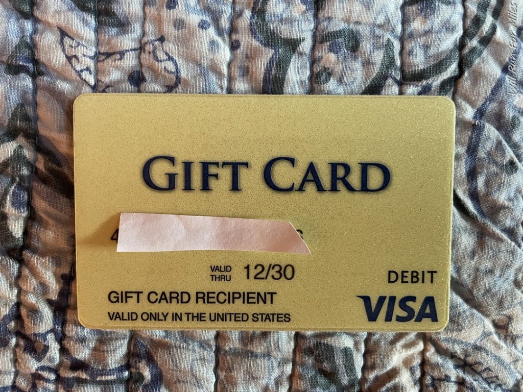 a gold gift card on a blue and white fabric