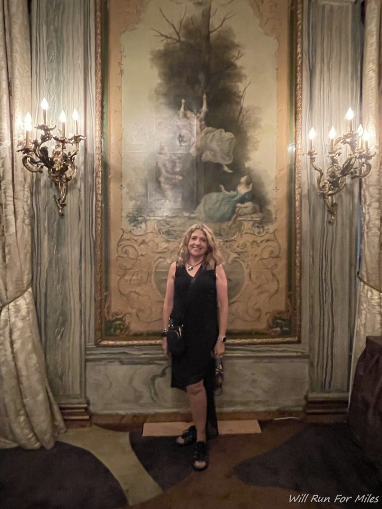 a woman standing in front of a painting