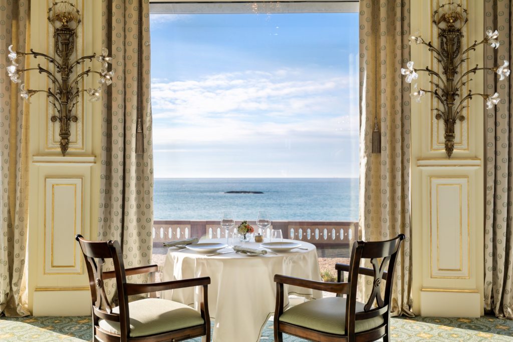 a table set up for a dinner with a view of the ocean