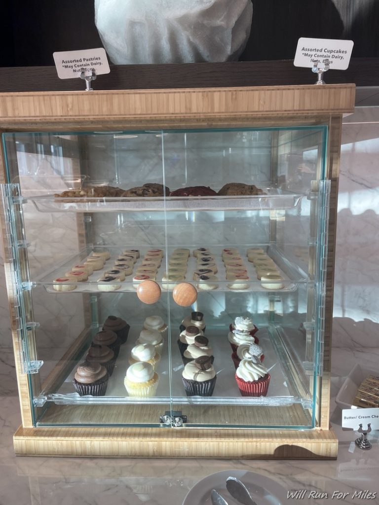 a glass case with cupcakes on it