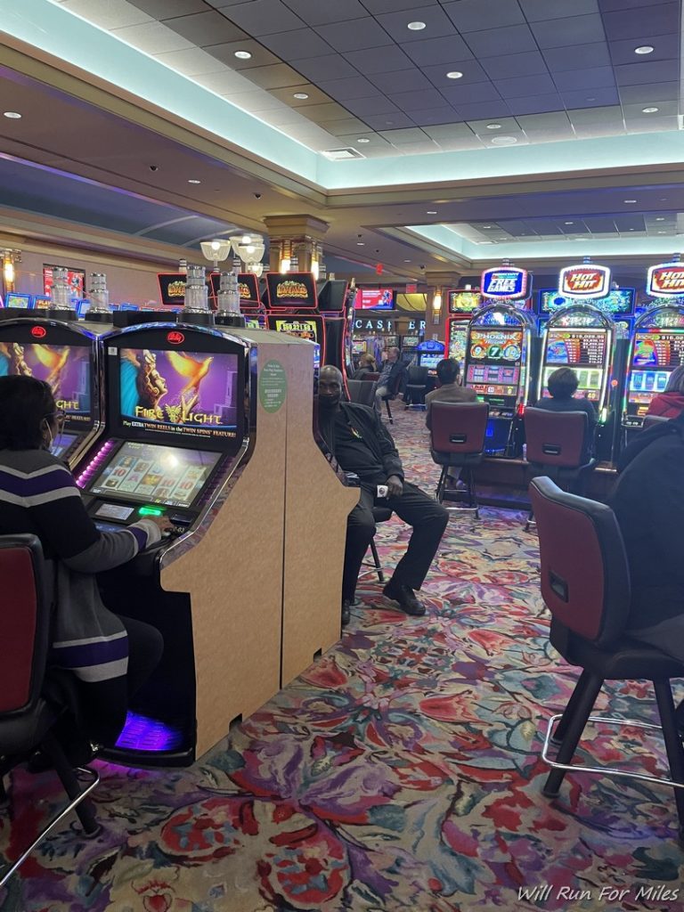 a group of people playing slot machines in a casino