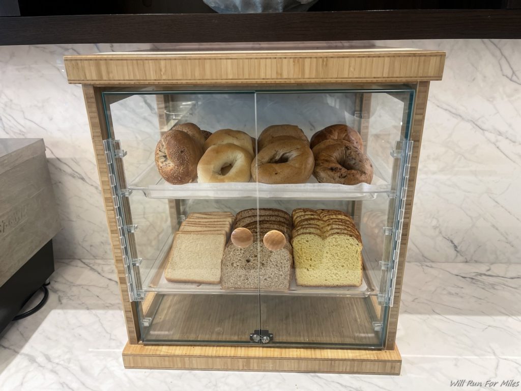 a glass case with different types of bread