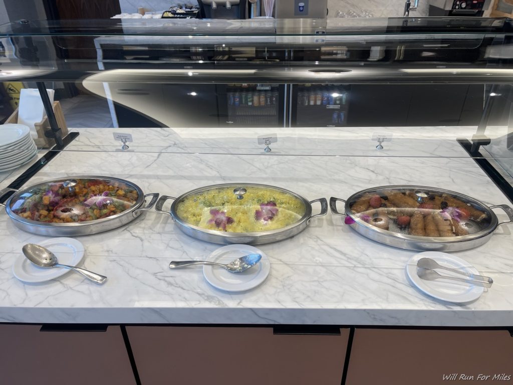 food in a buffet with a glass cover