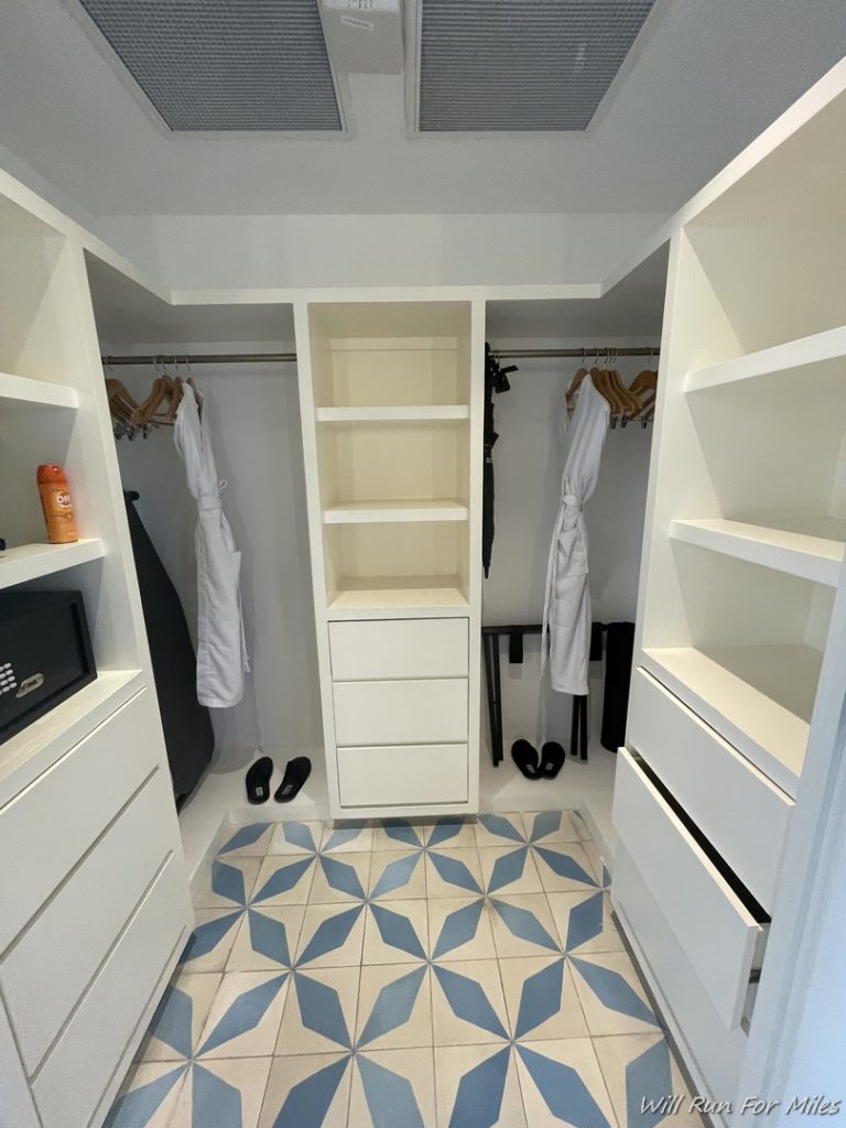 a white closet with shelves and white cabinets