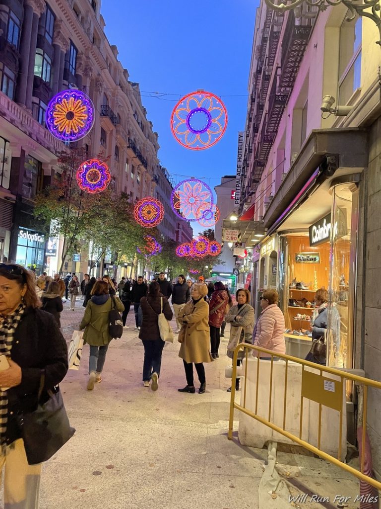 a group of people walking down a street with colorful decorations