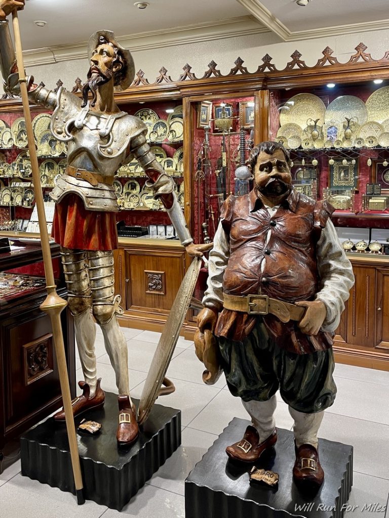 statues of a man in armor and a sword in a store