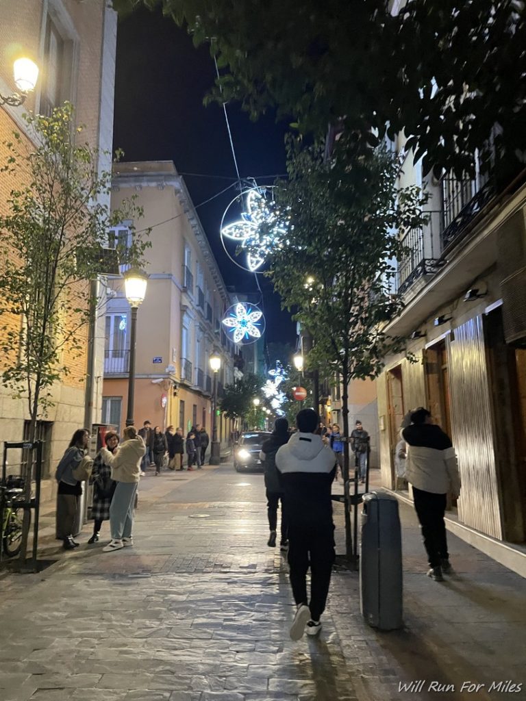 people walking down a street with lights