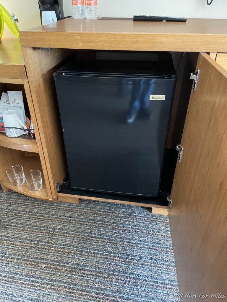 a small black refrigerator in a cabinet