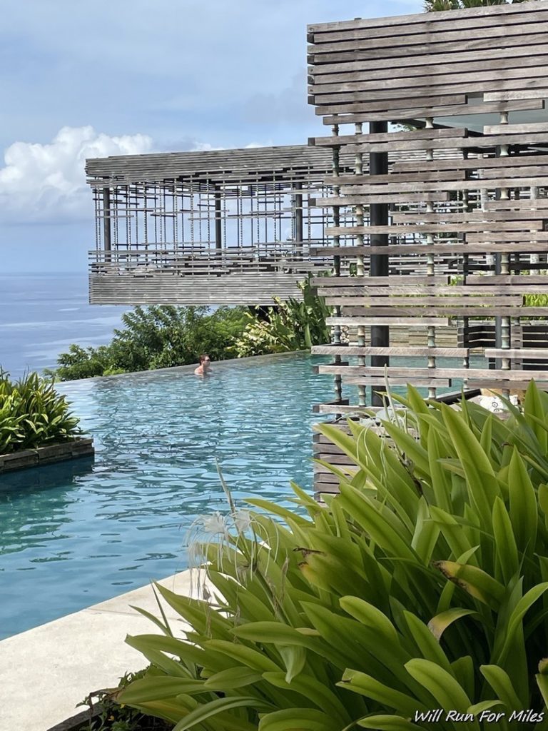 a pool with a wooden structure and a person swimming in it