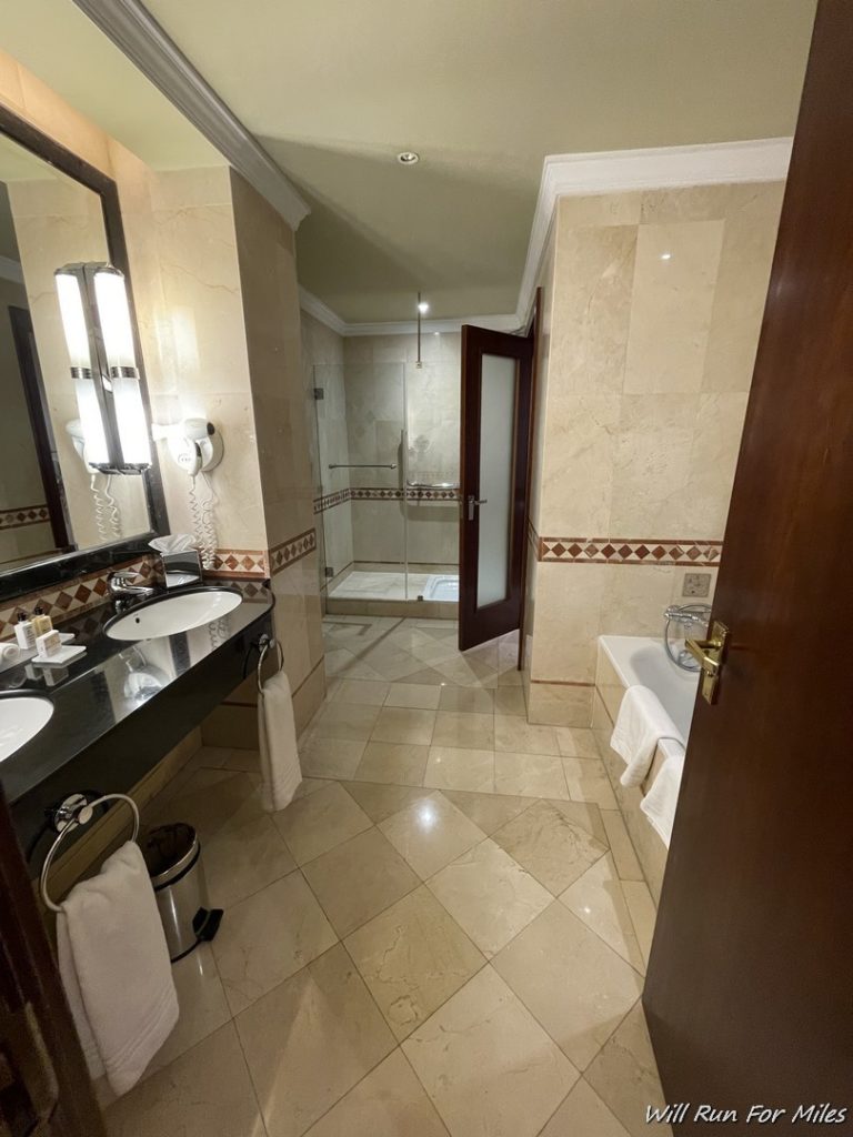 a bathroom with marble tiles and a sink and a shower