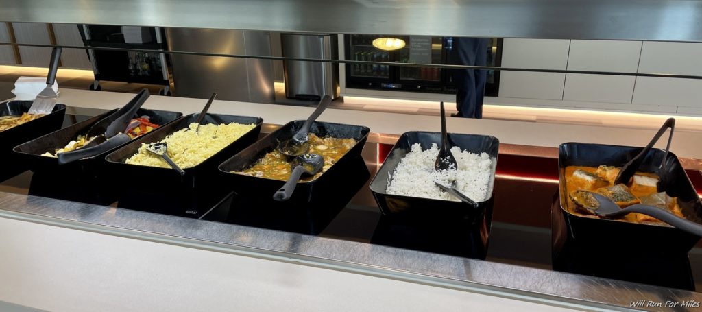 a row of black rectangular containers with food in them