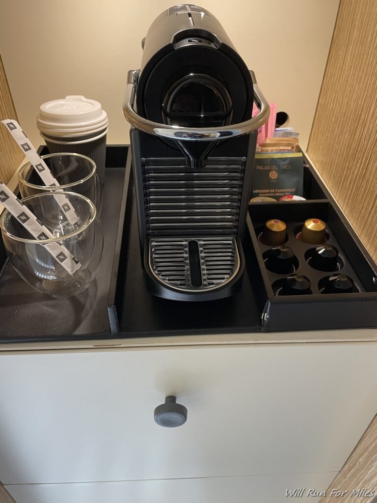 a coffee machine and cups on a drawer