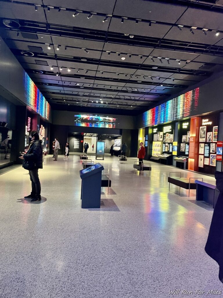 a room with many people standing in front of a display