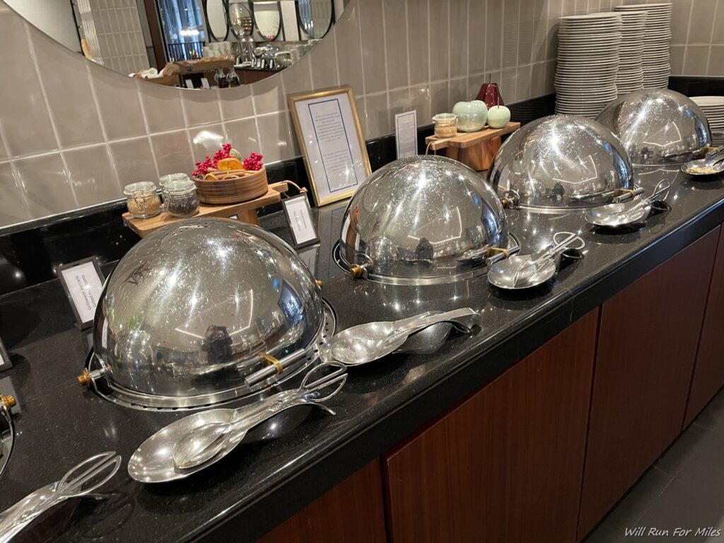 a group of silver bowls and spoons on a counter