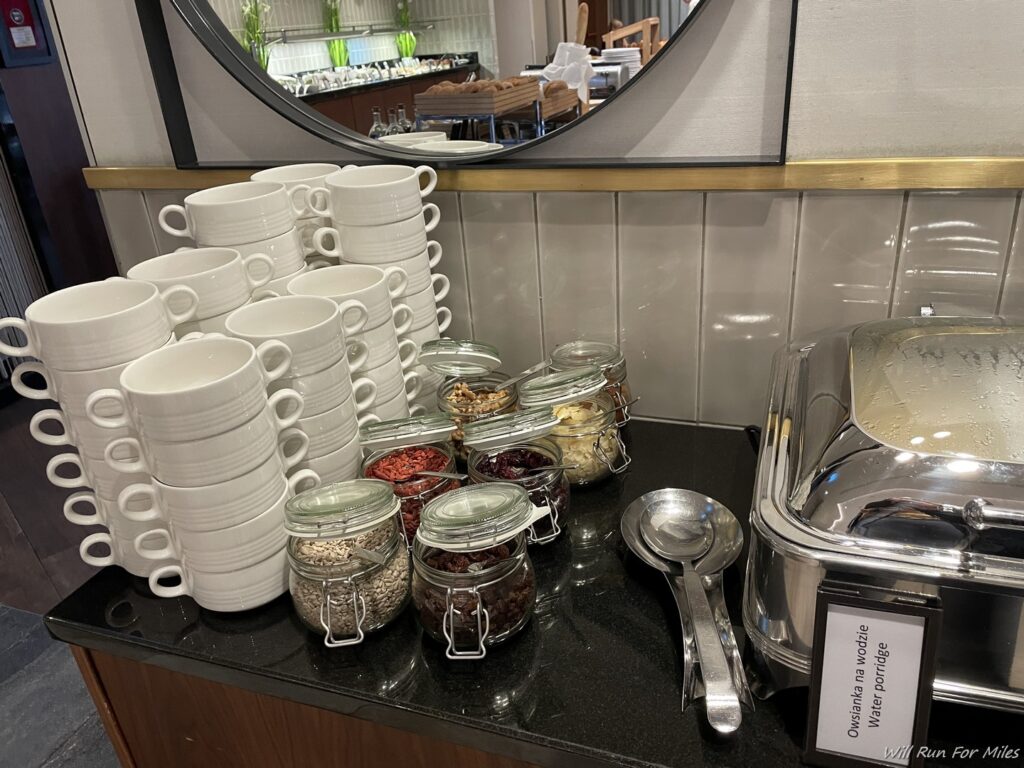 a group of white mugs and jars of food on a counter