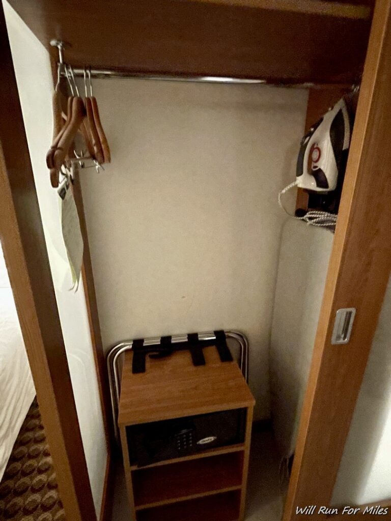 a closet with a small wooden box and swingers