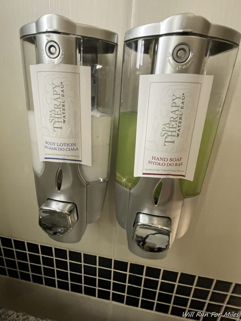 a couple of soap dispensers on a wall