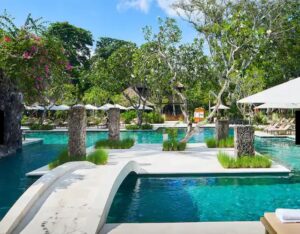 a swimming pool with trees and umbrellas