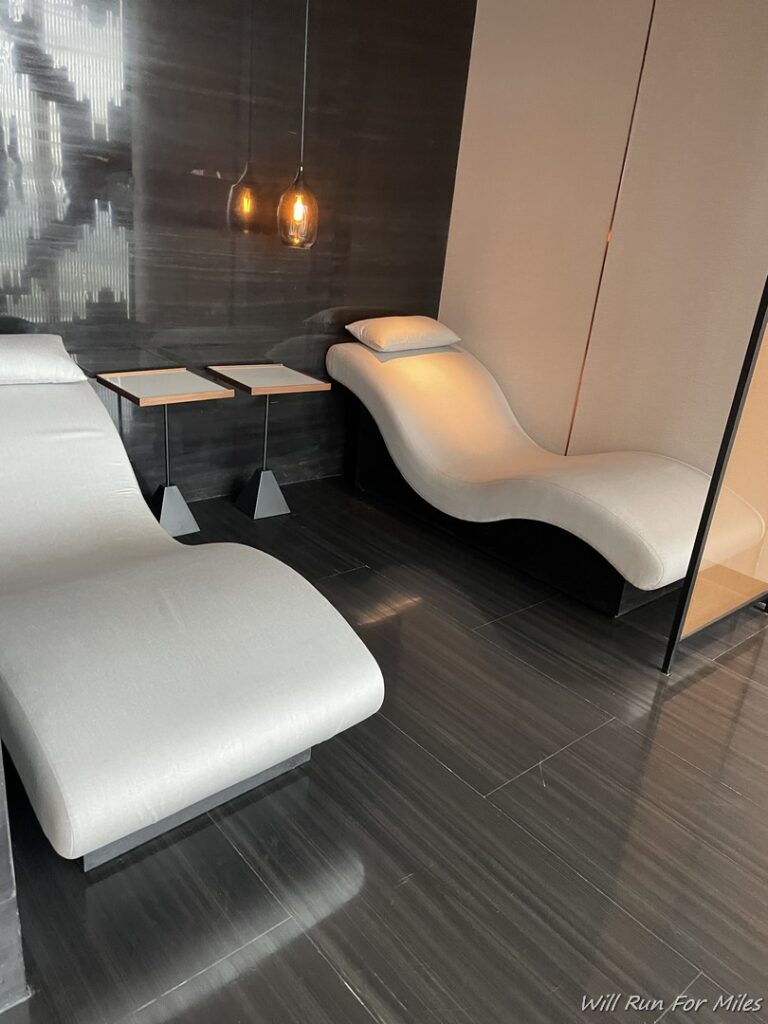 a room with white chairs and a black tile floor