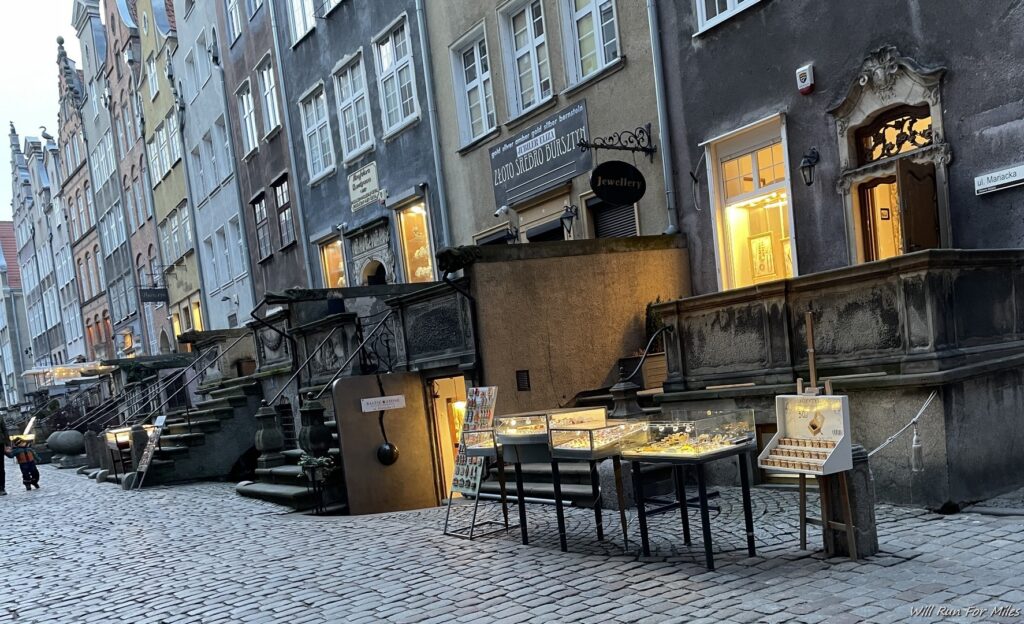 a street with a stone walkway and a display of jewelry