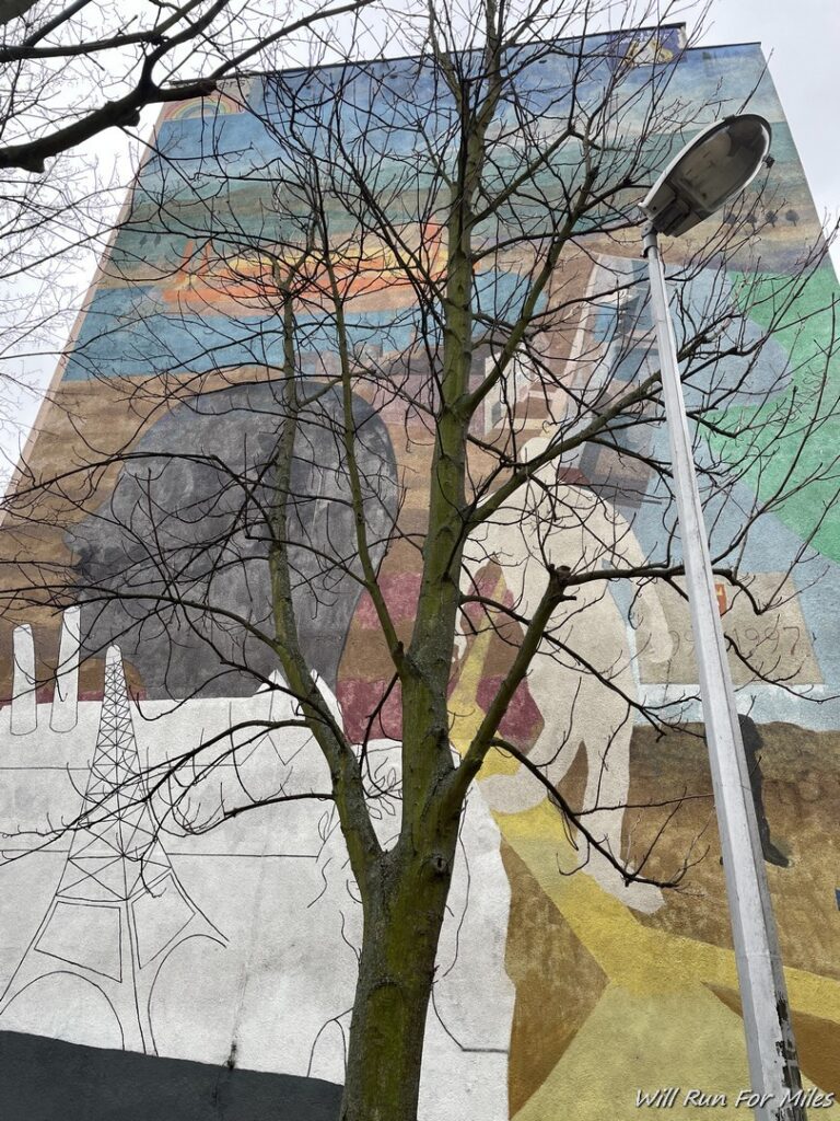 a tree next to a mural