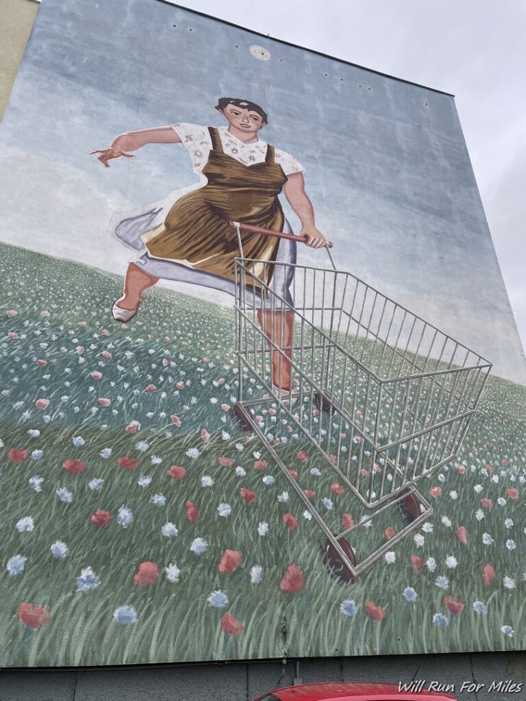 a mural of a woman pushing a shopping cart