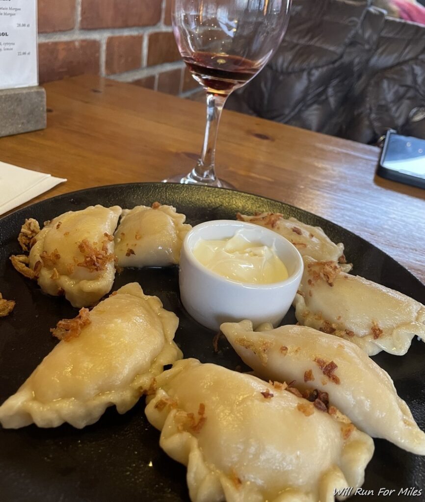 a plate of dumplings and a glass of wine