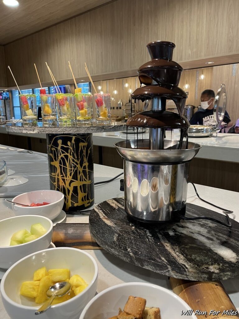 a chocolate fountain with fruit on sticks