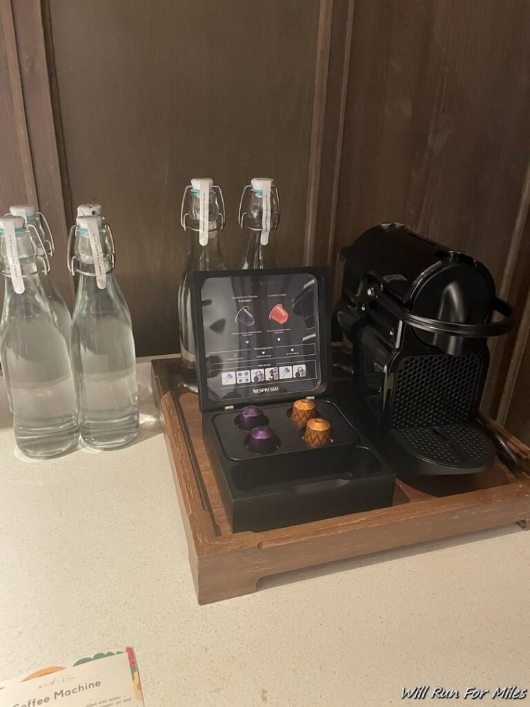 a coffee machine and bottles on a tray