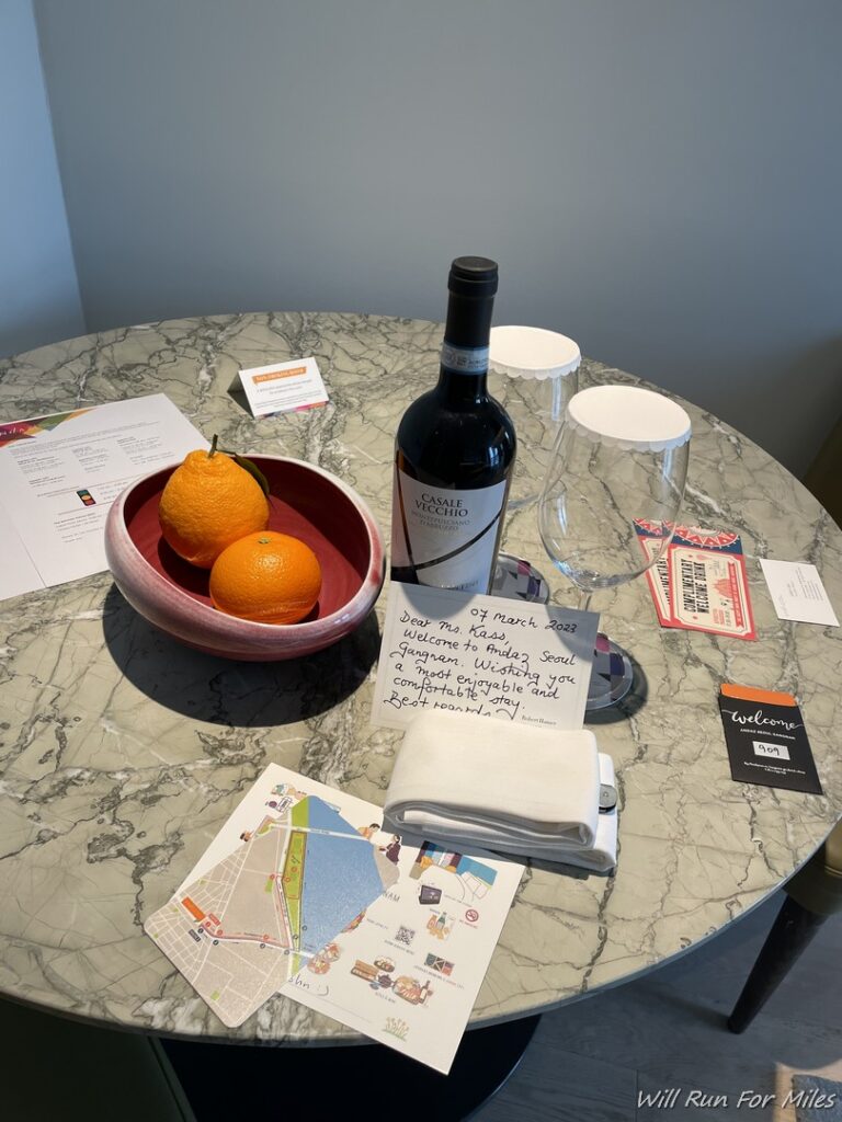 a table with a wine bottle and oranges