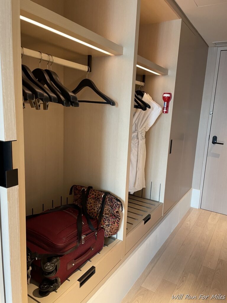 a closet with a suitcase and swingers