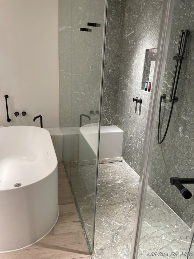 a bathroom with a glass shower and tub
