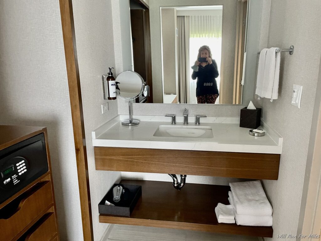 a woman taking a picture of a bathroom sink