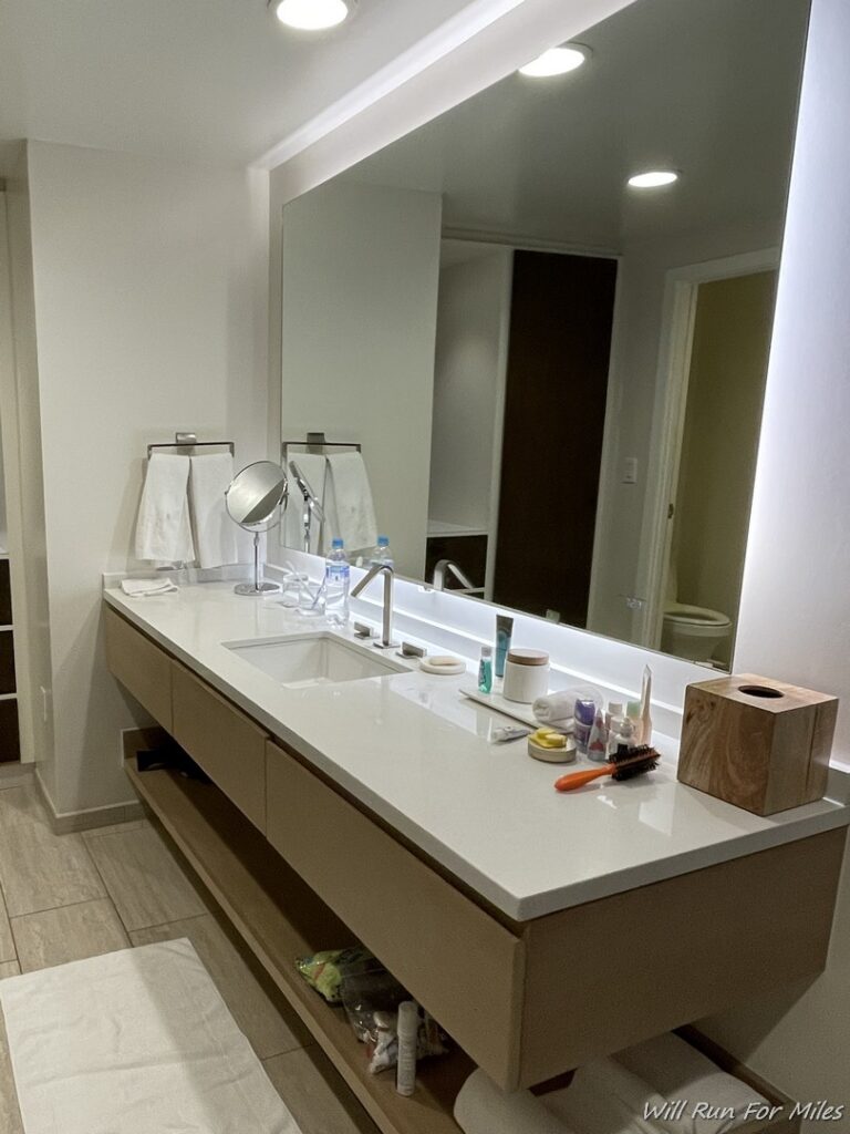 a bathroom with a large mirror and a white countertop